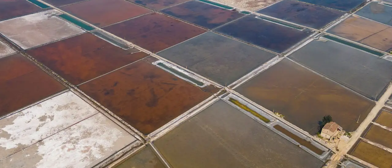 Aerial view of salt evaporation ponds, each basin a different colour